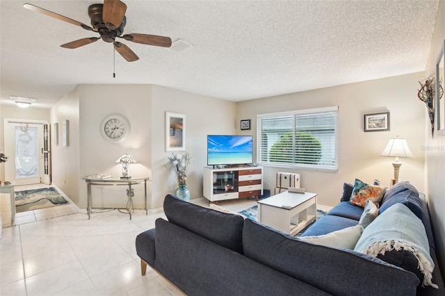 tiled living room featuring visible vents, baseboards, a ceiling fan, radiator heating unit, and a textured ceiling