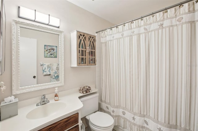 full bath with a shower with curtain, vanity, and toilet