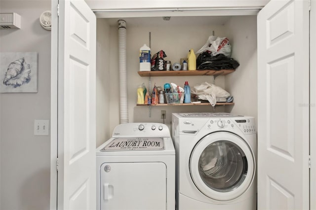 clothes washing area featuring laundry area and washer and clothes dryer