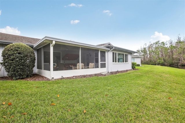 rear view of property with a sunroom and a yard