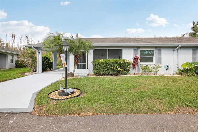 ranch-style home with driveway, a front yard, and stucco siding