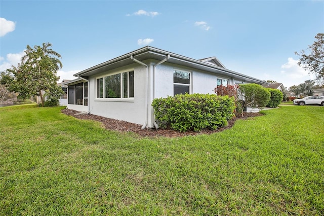 view of home's exterior with stucco siding and a yard