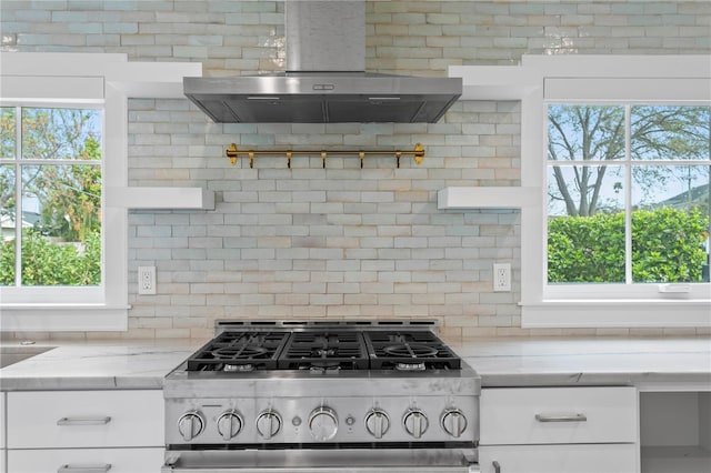 kitchen with open shelves, white cabinets, light stone countertops, wall chimney exhaust hood, and stainless steel range with gas stovetop