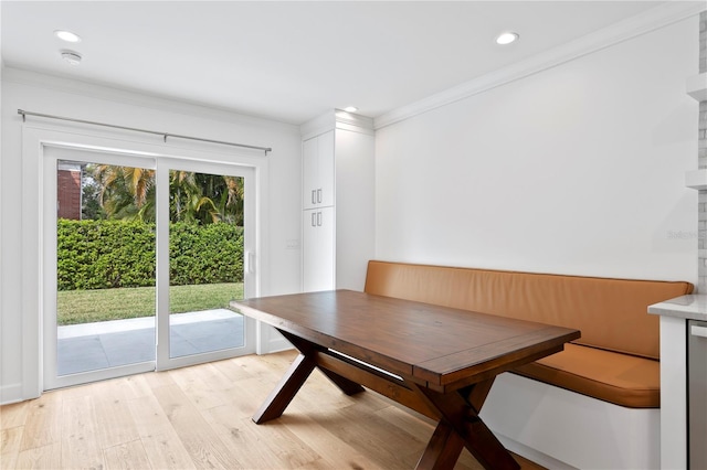 unfurnished dining area featuring breakfast area, light wood-type flooring, crown molding, and recessed lighting