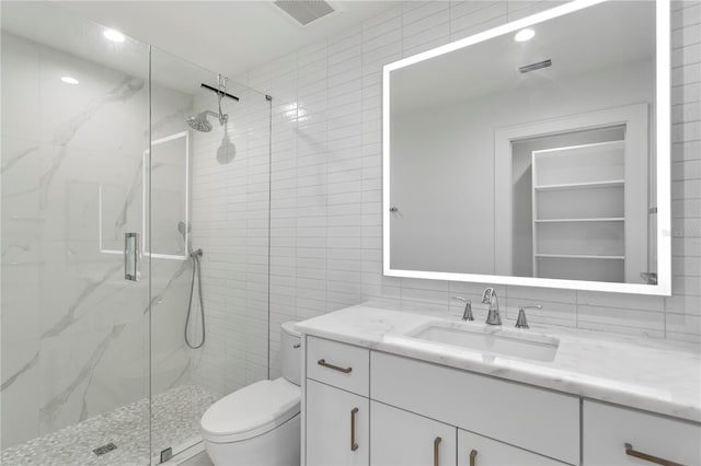 bathroom featuring toilet, visible vents, tile walls, a marble finish shower, and tasteful backsplash