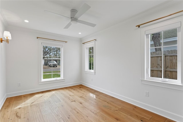 spare room featuring light wood-style flooring, baseboards, and crown molding