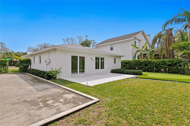 rear view of house featuring a patio area, fence, and stucco siding