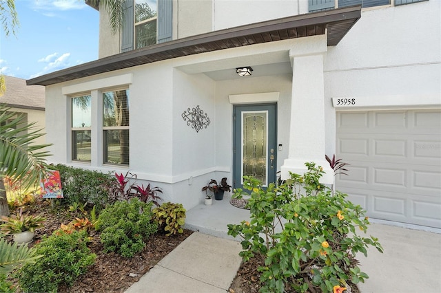 doorway to property with a garage and stucco siding