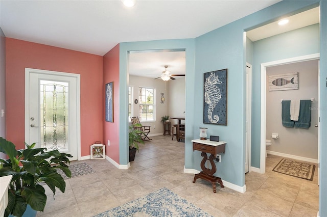 foyer with ceiling fan, light tile patterned flooring, and baseboards