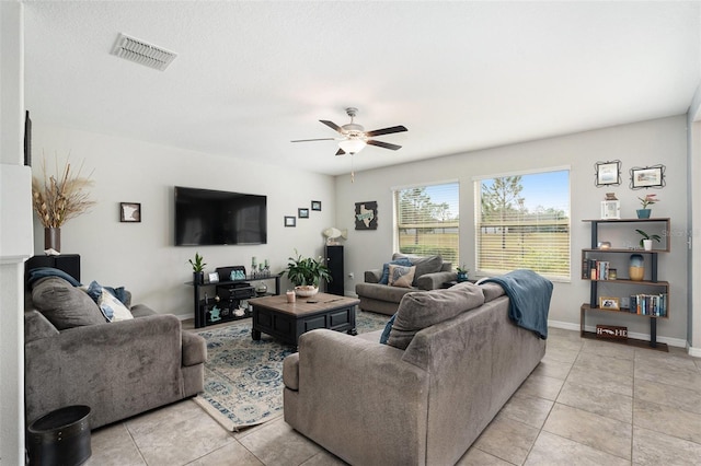 living room featuring ceiling fan, light tile patterned flooring, visible vents, and baseboards