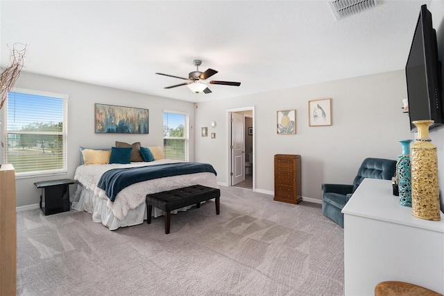 bedroom with a ceiling fan, light colored carpet, visible vents, and baseboards