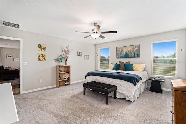 bedroom featuring visible vents, a ceiling fan, carpet flooring, a textured ceiling, and baseboards