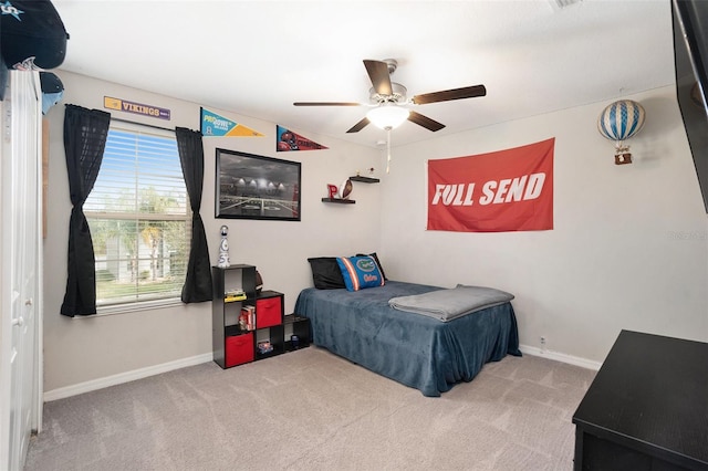 carpeted bedroom with ceiling fan and baseboards