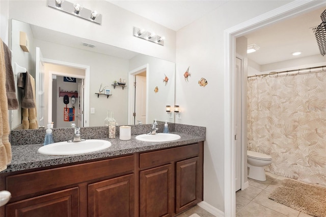 bathroom with tile patterned flooring, a sink, toilet, and double vanity