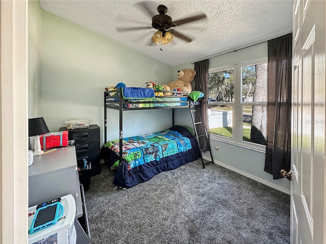 bedroom featuring baseboards, dark carpet, ceiling fan, and a textured ceiling