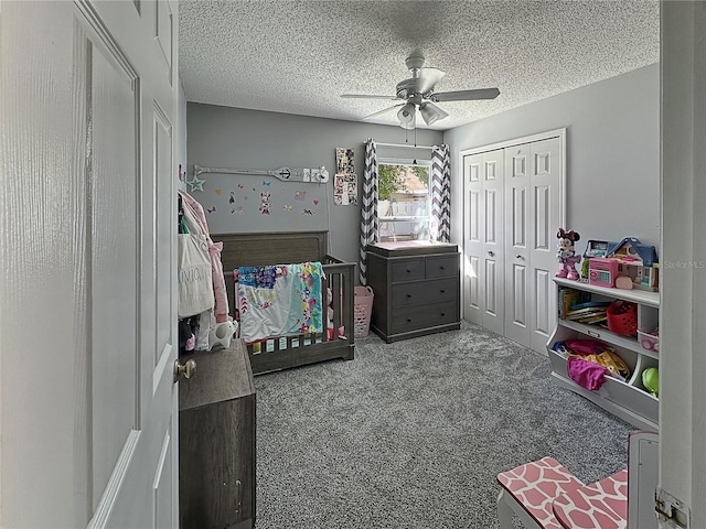 carpeted bedroom featuring a closet, a ceiling fan, and a textured ceiling