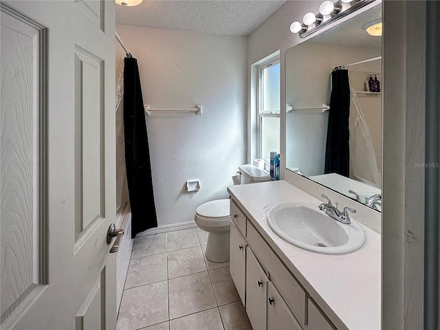 full bathroom with a textured ceiling, toilet, vanity, baseboards, and tile patterned floors