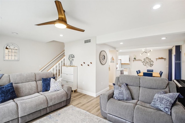 living room with baseboards, light wood-type flooring, and recessed lighting