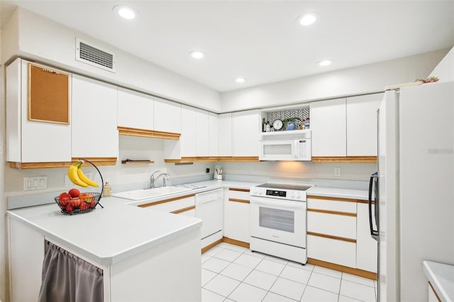 kitchen with white appliances, a sink, visible vents, white cabinetry, and light countertops