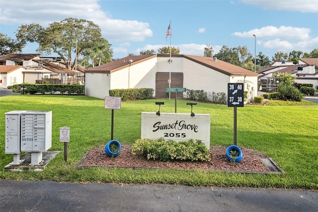 community sign featuring a residential view and a lawn