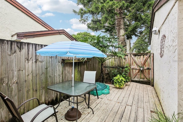 wooden terrace featuring outdoor dining space and fence