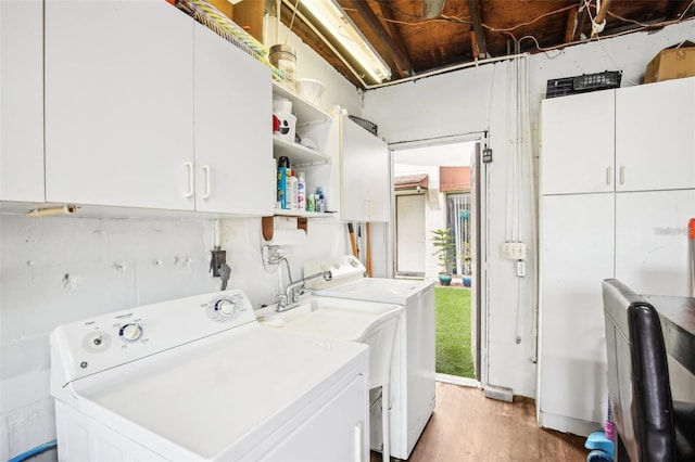 clothes washing area featuring cabinet space, light wood-style flooring, and independent washer and dryer