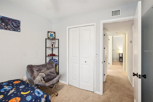 bedroom with light carpet, a closet, visible vents, and baseboards