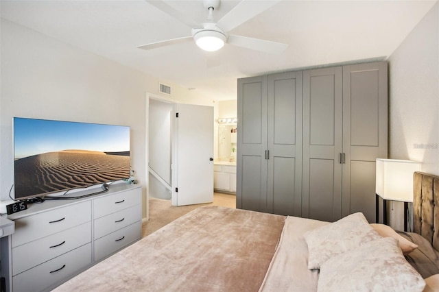 bedroom featuring a ceiling fan, visible vents, connected bathroom, and light carpet