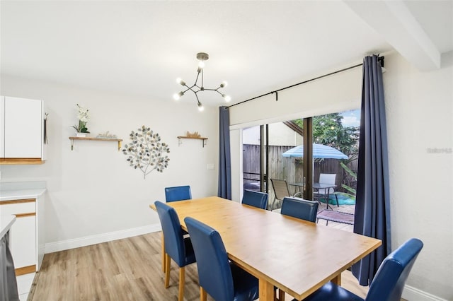 dining area with a chandelier, beamed ceiling, light wood-type flooring, and baseboards