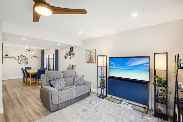 living area featuring light wood-style flooring, baseboards, a chandelier, and recessed lighting