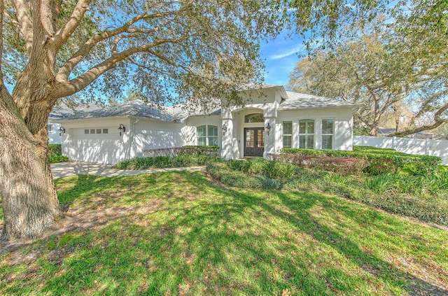 ranch-style house featuring a garage, french doors, fence, and stucco siding