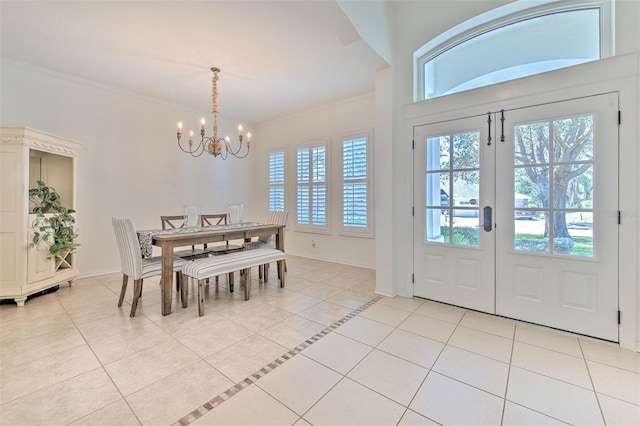 dining area with a chandelier, light tile patterned flooring, crown molding, and baseboards