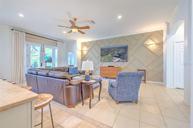 living area with light tile patterned flooring, recessed lighting, an accent wall, ornamental molding, and french doors