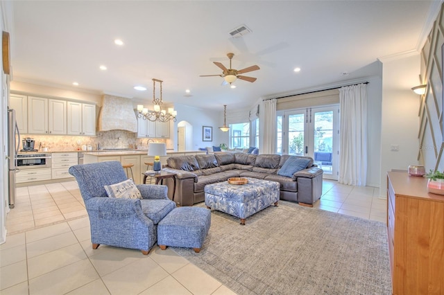 living room with visible vents, ornamental molding, ceiling fan with notable chandelier, light tile patterned flooring, and recessed lighting