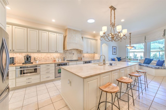 kitchen featuring light tile patterned floors, appliances with stainless steel finishes, custom exhaust hood, and a sink