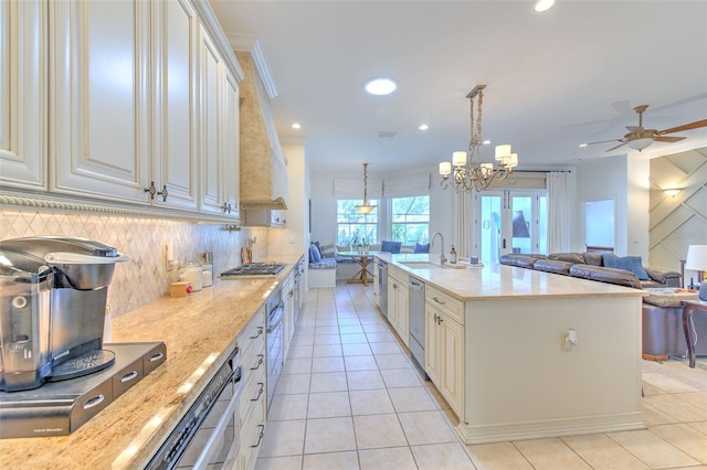 kitchen with open floor plan, appliances with stainless steel finishes, light tile patterned floors, and decorative backsplash