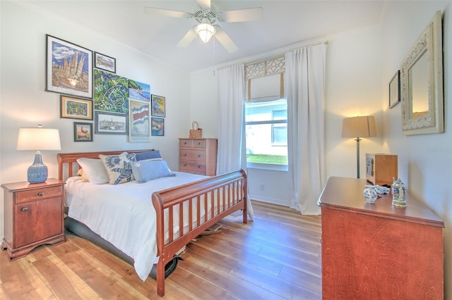 bedroom featuring baseboards, ceiling fan, and light wood finished floors