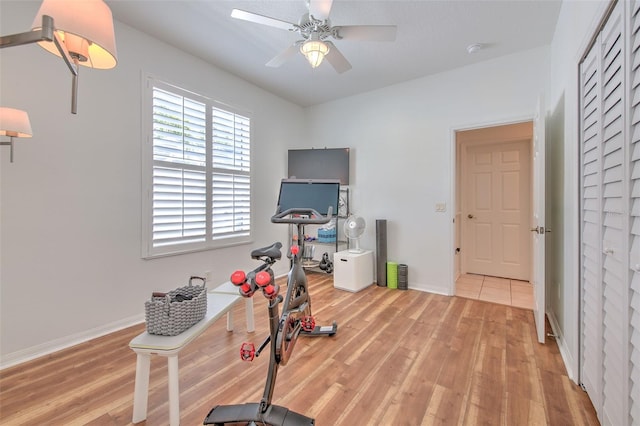 workout room with ceiling fan, baseboards, and wood finished floors