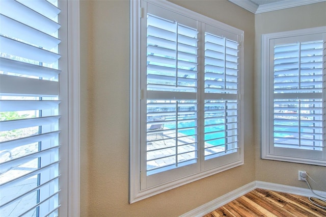 room details featuring crown molding, wood finished floors, and baseboards