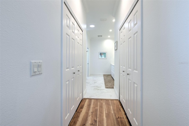 corridor with recessed lighting, visible vents, baseboards, marble finish floor, and crown molding