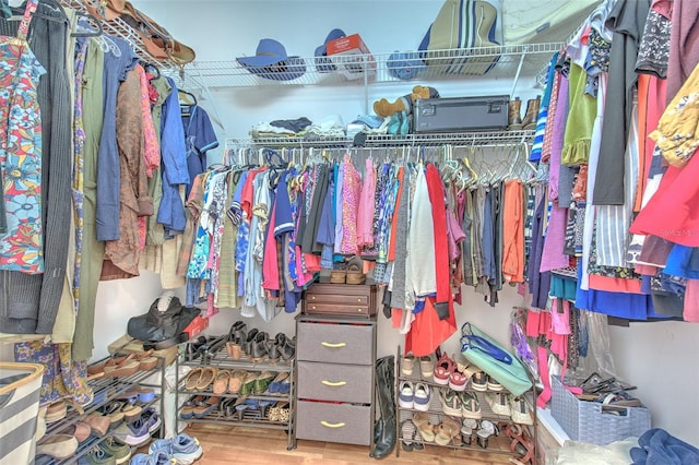 walk in closet with wood finished floors