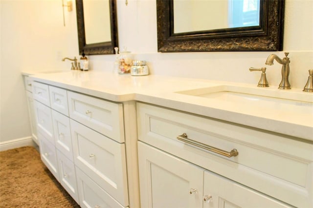 full bath with a sink, baseboards, and double vanity