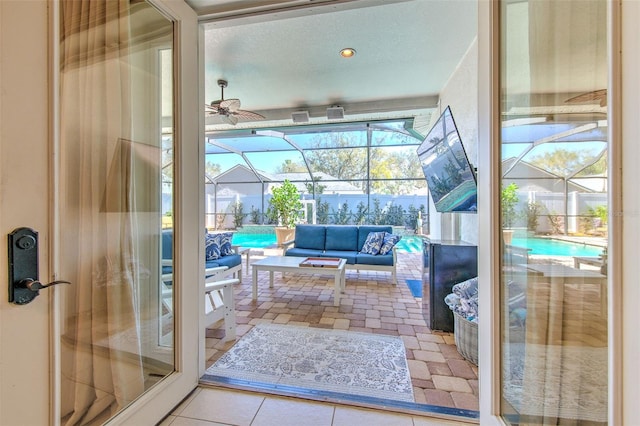 doorway featuring tile patterned flooring, a sunroom, and ceiling fan