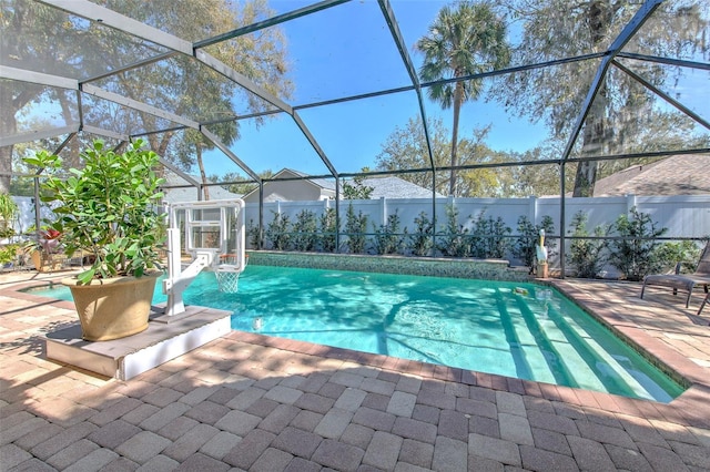 view of swimming pool with glass enclosure, fence, a fenced in pool, and a patio