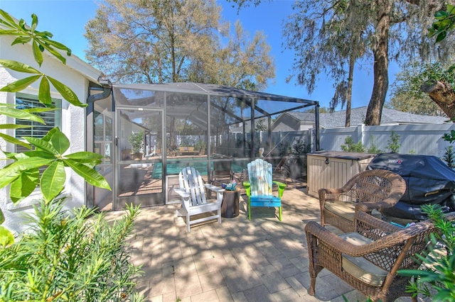 view of patio / terrace featuring glass enclosure, a grill, fence, and an outdoor pool