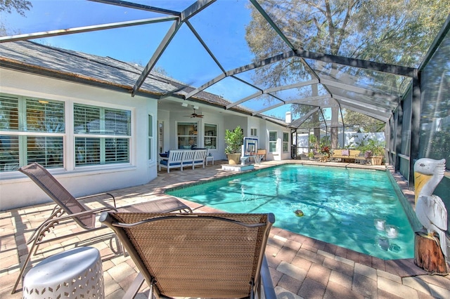 pool featuring a lanai, a patio area, and ceiling fan