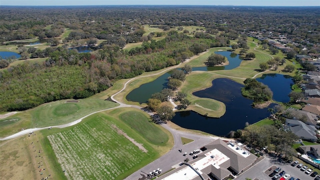 drone / aerial view with a water view, a forest view, and golf course view