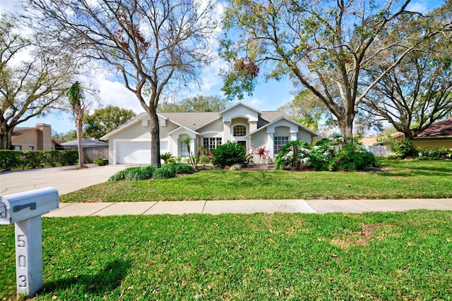 ranch-style home with a garage, concrete driveway, a front yard, and fence