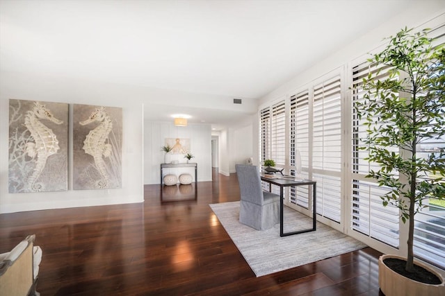 living area with dark wood-style flooring and visible vents