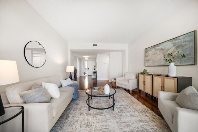 living room with vaulted ceiling, wood finished floors, and visible vents